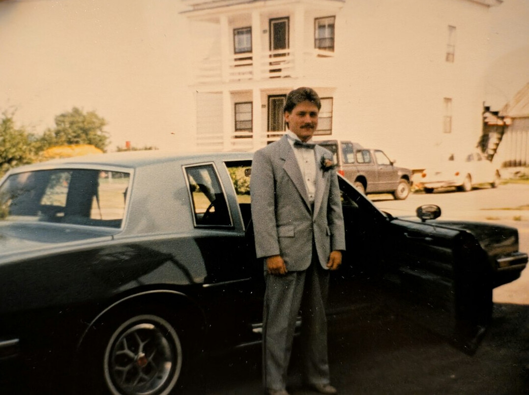 Portrait of a man in his fifties with short grey hair in a dark suit
