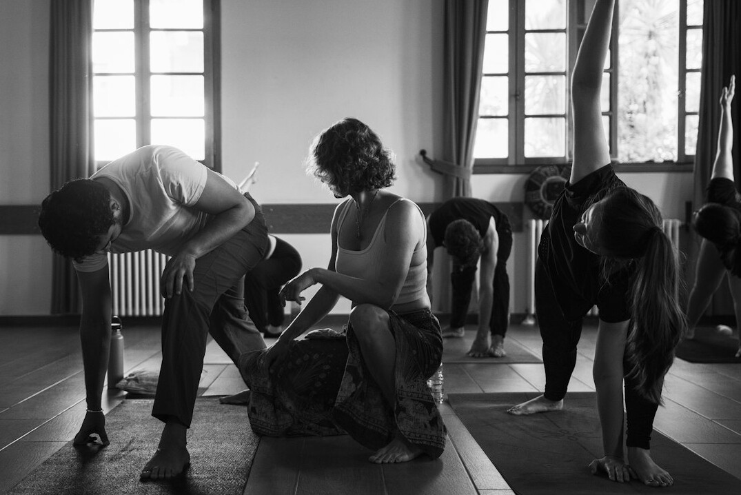 Participants in a circle practicing breathing and posture in a bright room